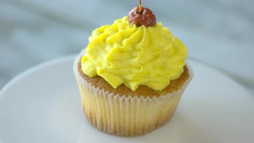 Single Cupcake with Yellow Frosting and Cherry