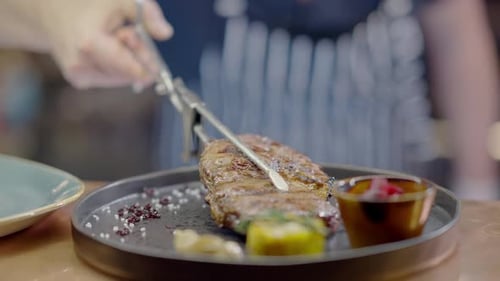 Unrecognizable Male Cook Serving Delicious Smoked Meat on Plate in Kitchen