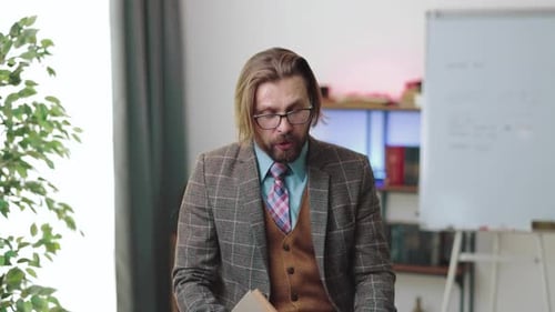 Man in Suit Speaking Holding Book