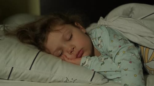 Child Sleeping Peacefully in Bed at Night