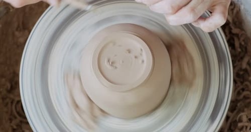 Female Potter Sitting and Makes a Cup on the Pottery Wheel. Woman Making Ceramic Item. Pottery
