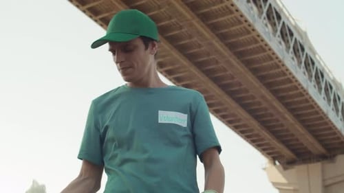 Volunteer Holding Trash Under an Urban Bridge