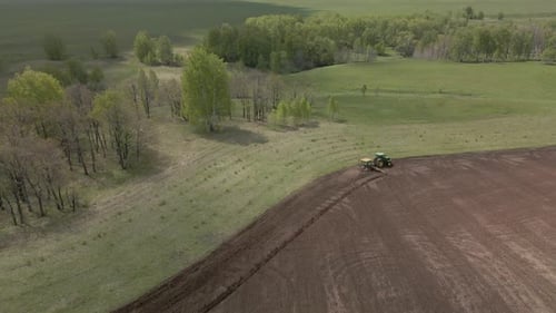 Tractor plows and cultivates the land for sowing in spring