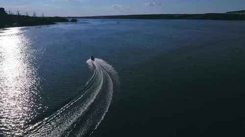Boot mit Menschen, die auf dem Fluss schwimmen. Drohnenaufnahme eines Segelmotorschiffs in der Mitte des Flusses