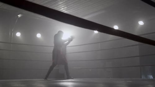 Boxer Shadow Boxing in Smoky Boxing Ring