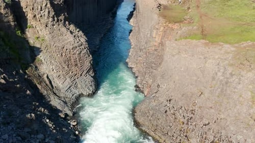 Aerial Descending Footage of Stream Flowing in Straight Narrow Gorge with Rock Walls