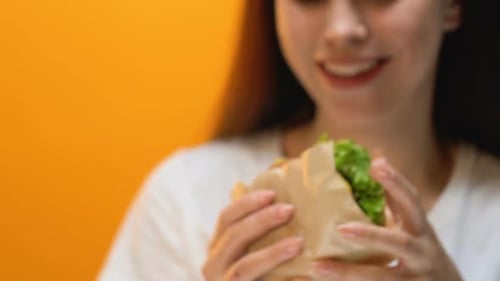 Man Bringing Hamburger for Woman, Young Lady Greedily Eating, Bulimia, Close Up