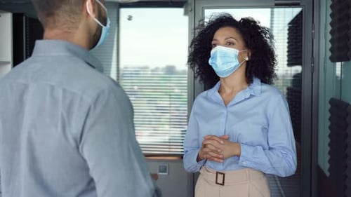 Multiracial Employees Colleagues Talking Wearing Masks Standing in Office