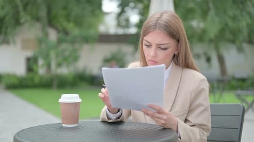 Woman Reading Documents at Urban Outdoor Table