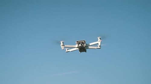 White Drone Hanging in Air or Flying on Nature Background. Slow Motion Shot.