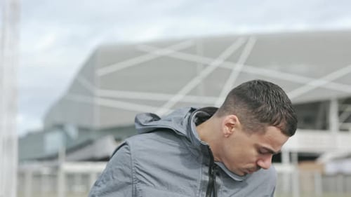 Young Handsome Guy Walking Down The Street. He Pulls Cell Phone Out Of His Pocket And Tosses It. At