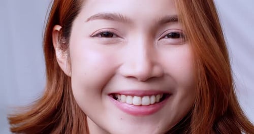 Young Asian woman in close up face portrait smile happy. Slow motion.