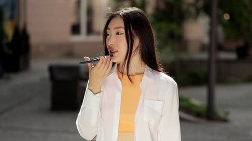 Woman Using Voice Message App in the City