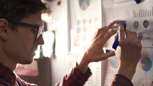 Young Adult Analyzes Business Data in Workplace