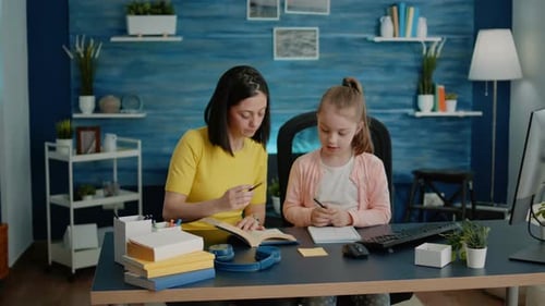 Woman Helps Girl With Schoolwork at Home