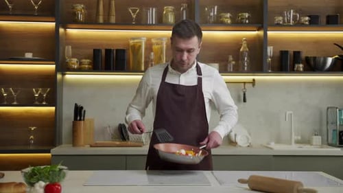 Man Chef Fries Vegetables on Pan Stirring with Spatula