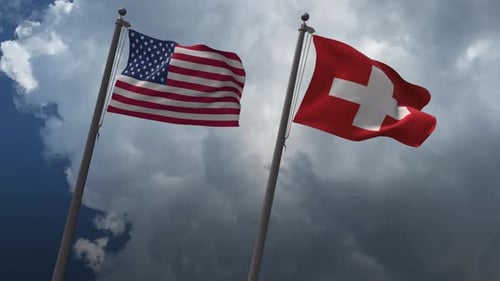 United States and Switzerland Flags Waving against Cloudy Sky