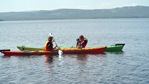 Couple Kayaking on Lake With Beautiful Natural Landscape