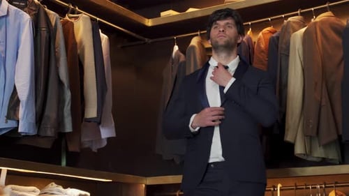 Elegant Man Trying on a Jacket in a Shop