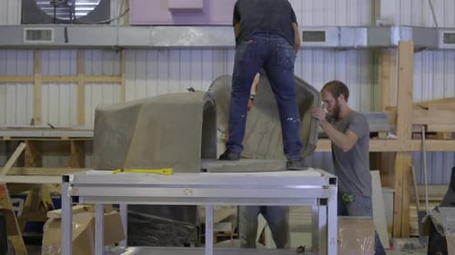 Three workers put a concrete mold in place