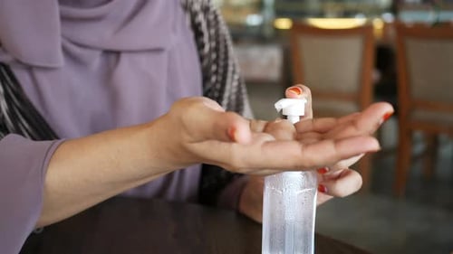 Junge Frauen verwenden Händedesinfektionsmittel im Café