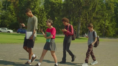 Busy with Cellphones Diverse Multiethnic Students Going to Lecture at Campus