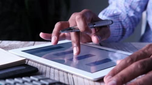 Man's Hand Working on Digital Tablet at Office Desk, Using Self Created Chart