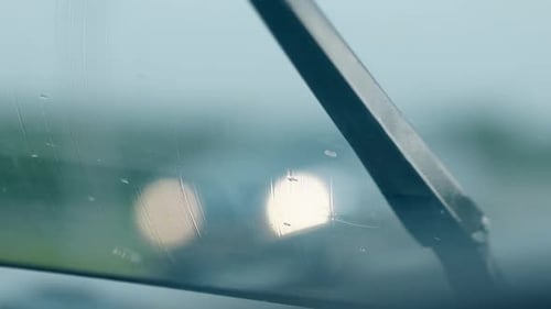 Close View Black Wiper Cleans Raindrops From Wet Car Glass