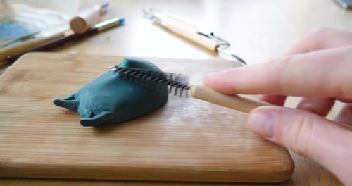 Clay Being Sculpted on a Wooden Board