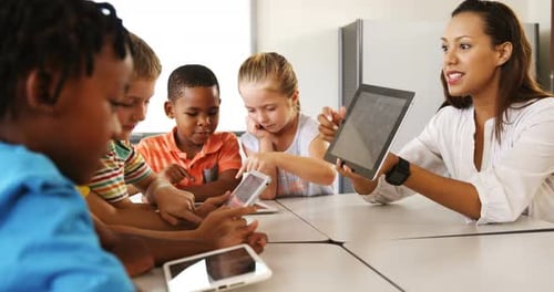 Teacher teaching kid on digital tablet in library
