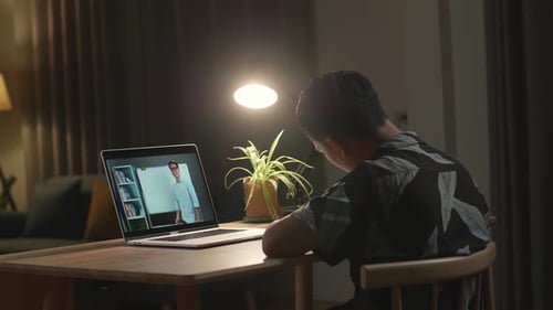 Child Watches Online Lesson on Laptop at Night