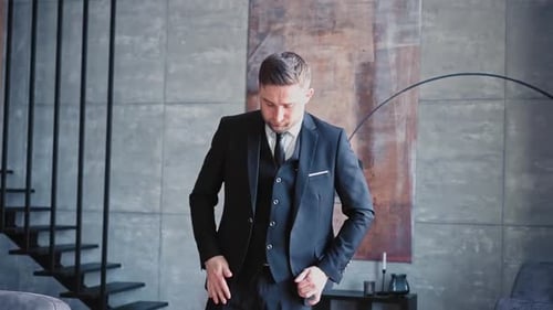 Man in Suit Adjusts Jacket Indoors