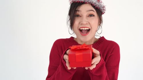 Smiling Woman Offers Festive Red Wrapped Gift