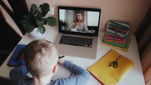 Boy Attends Online Schooling at His Desk