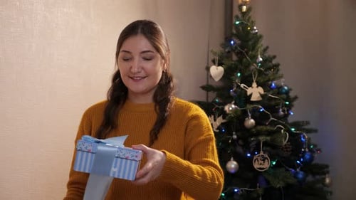 Woman Opens a Gift at Christmas Time