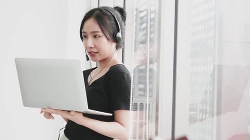Woman Using Laptop on Video Call in Office