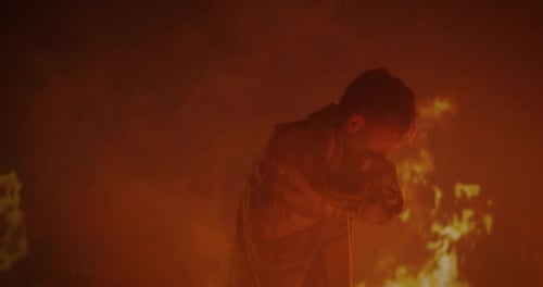 Person Standing in Front of Blazing Fire at Night