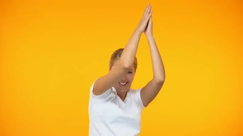 Enthusiastic Woman Dancing Against Yellow Background