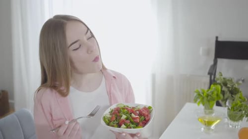 Portrait of Happy Caucasian Woman Eating Fresh Spring Salad of Tomatoes, Cucumbers and Greenery