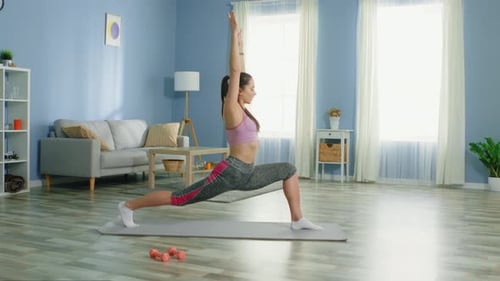 Woman Performing Lunge Exercise on Yoga Mat