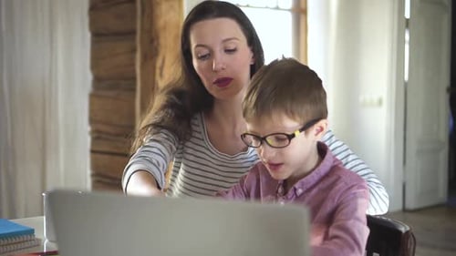 Woman and Boy Working on Laptop at Home
