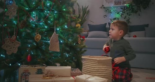 Boy Decorates Christmas Tree in Cozy Home