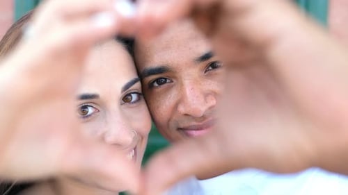 Smiling Couple Making Heart Shape with Hands