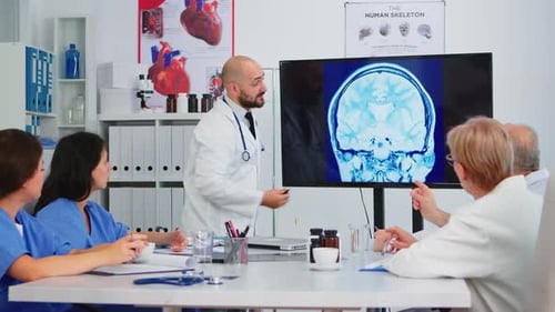 Medical Professionals Discussing Brain Scan in Bright Office