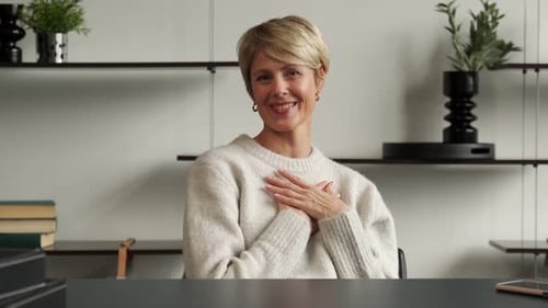 Woman Waving Hello at Office Desk