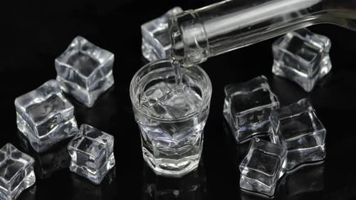 Clear Liquid Poured into a Glass with Ice