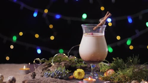 Homemade Traditional Christmas Eggnog Drink in Glass with Ground Nutmeg and Cinnamon Decorating with