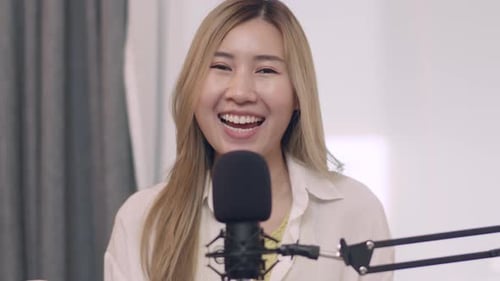 Woman Broadcasting into Microphone in Studio
