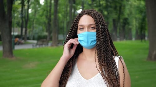 Woman Takes Off Mask and Smiles in Park