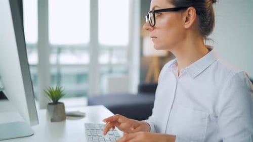 Woman Typing on Computer Keyboard in Office